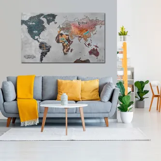 Mapa-múndi texturado e colorido em quadro acima de sofá cinzento com almofadas amarelas