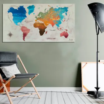 Mapa-múndi colorido com nomes manuscritos em tela pendurada numa parede cinzenta