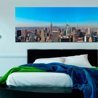 Quarto com cama e pintura panorâmica do horizonte de Nova Iorque sobre a cabeceira