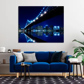 Cidade à noite com ponte iluminada e reflexo nas águas