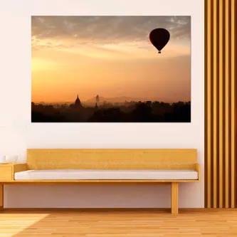 Pintura voando pelo céu com balão sobrevoando paisagem enevoada ao pôr do sol