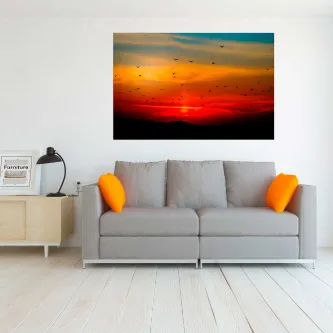 Pintura de céu vermelho com aves em voo sobre horizonte, pendurada na parede