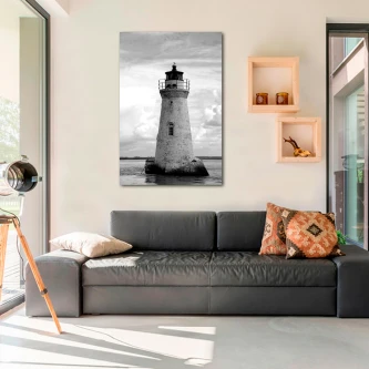 Pintura a preto e branco de farol pendurada acima de sofá na sala