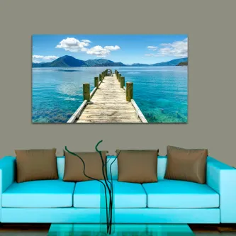 Caixa de doca seca com imagem de passadiço de madeira sobre água turquesa e montanhas