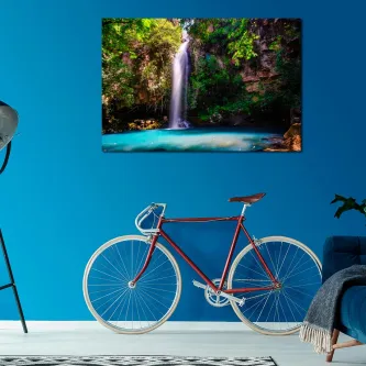 Pintura de cachoeira pendurada em parede azul acima de bicicleta vermelha