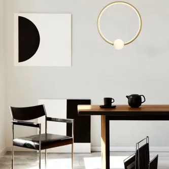 Candeeiro de teto Celia Roda em anel dourado com esfera luminosa sobre mesa