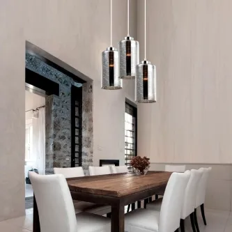 Candeeiro de teto Blake Round com três cilindros metálicos suspensos sobre mesa