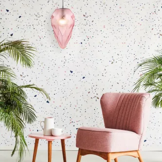 Candeeiro de teto globo cromado pendente rosa acima de poltrona rosa e mesa com plantas