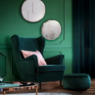 Espelho Aries redondo duplo na parede verde sobre poltrona em veludo verde