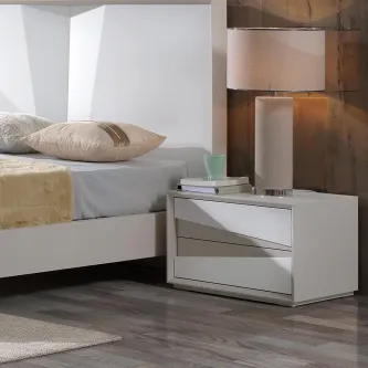 Mesa de cabeceira Plain branca com duas gavetas, candeeiro e livros ao lado da cama