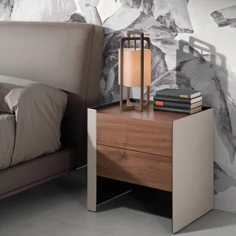 Mesa de cabeceira Padova em madeira com duas gavetas, abajur e livros ao lado da cama