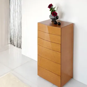 Camiseiro Puramis em madeira clara com cinco gavetas e vaso com flores