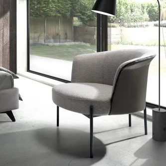 Poltrona Dubai cinzenta com pernas metálicas finas junto à janela