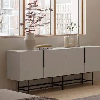 Aparador Eldia Lac branco lacado com pés metálicos pretos e vasos decorativos junto à janela