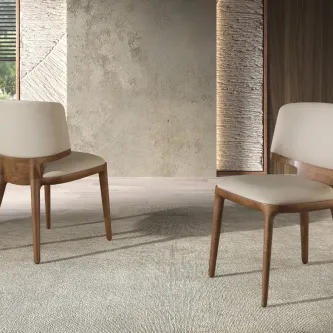 Cadeira Sinatra em madeira com estofado claro, duas cadeiras num interior minimalista