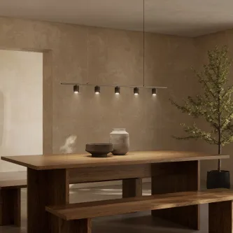 Candeeiro de teto Tea com barra e cinco focos suspenso sobre mesa de madeira