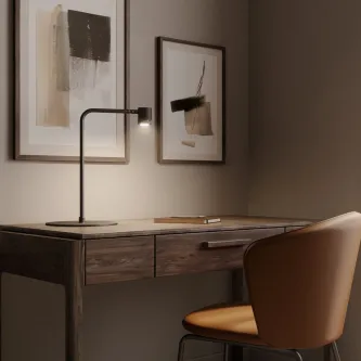 Candeeiro de mesa Tea preto com haste curva a iluminar secretária de madeira e cadeira