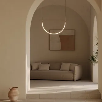Candeeiro suspenso Cram II em arco iluminando sala com sofá e vaso