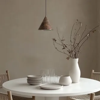 Candeeiro suspenso iconic sobre mesa redonda com loiça e vaso seco