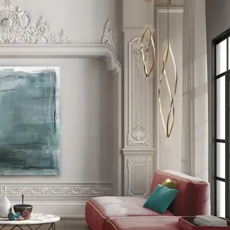 Suspensão Adele Baixa dourada com dois pendentes curvos junto a sofá vermelho