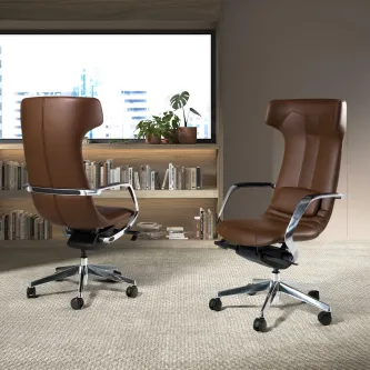 Duas cadeiras de escritório Celta em pele castanha, encosto alto, rodízios, num escritório