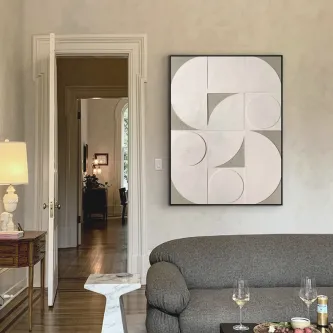 Quadro Geomia com formas geométricas brancas e cinzentas numa sala com sofá cinzento