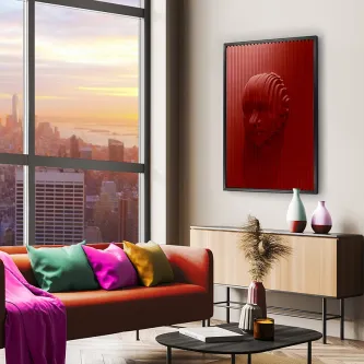 Quadro Red Face com rosto vermelho em relevo numa sala moderna junto a sofá colorido