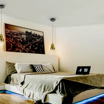 Candeeiro suspenso Aledis em vidro dourado sobre cabeceira de quarto moderno