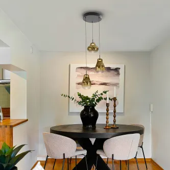 Candeeiro de teto Aledis 3L com três pendentes dourados sobre mesa de jantar