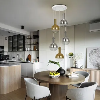 Candeeiro de teto Matices com esferas metálicas douradas e prateadas sobre mesa de jantar