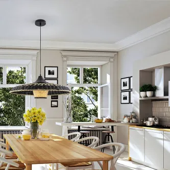 Candeeiro suspenso Fiji em rattan sobre mesa de madeira numa cozinha luminosa