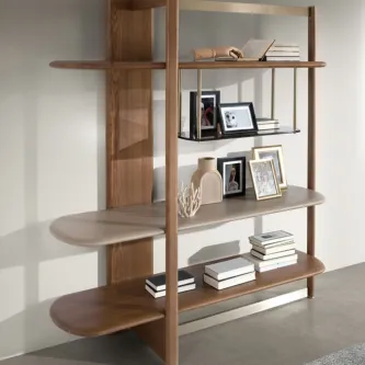 Livreiro Vidal em madeira com prateleiras arredondadas, livros e molduras decorativas