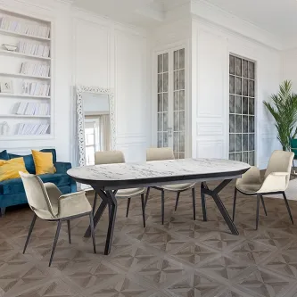 Mesa extensível Antea com tampo marmoreado e seis cadeiras numa sala luminosa