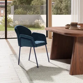 Cadeira Aslin azul escuro estofada com braços e pernas metálicas junto a mesa