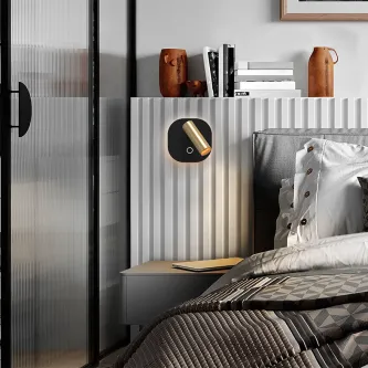 Aplique Biblos preto e dourado montado na parede junto à cabeceira da cama