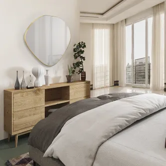 Espelho de forma orgânica com moldura dourada sobre móvel de madeira num quarto luminoso