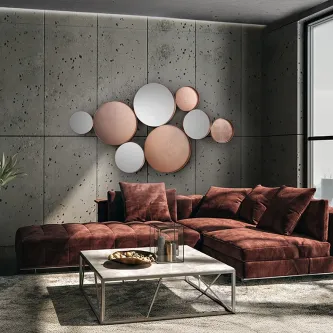 Espelho Malmo com vários discos espelhados em tons prateado e cobre numa parede de betão