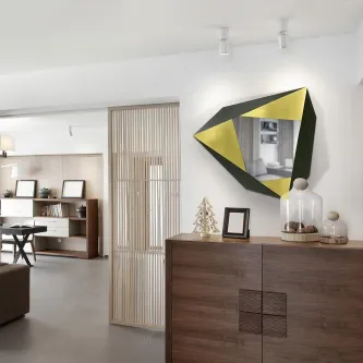 Espelho facetas geométrico dourado e preto pendurado acima de cómoda em sala moderna