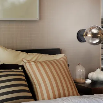 Aplique Dark metálico com globo de vidro iluminado junto à cabeceira