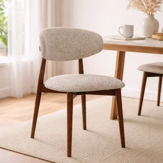 Cadeira Roya estofada bege com pernas em madeira junto a mesa de jantar