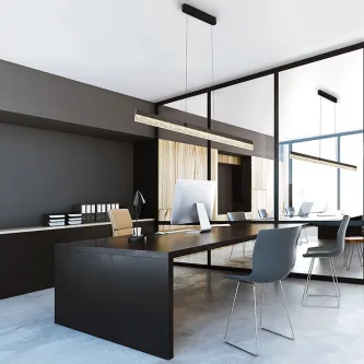 Candeeiro de teto Ixias linear suspenso sobre secretária num escritório moderno