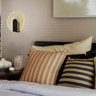 Aplique Auris redondo com anel luminoso junto a cabeceira de cama