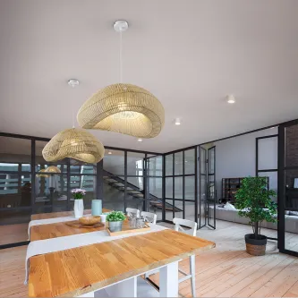 Candeeiro de teto Sabah 55 em rattan suspenso sobre mesa de madeira