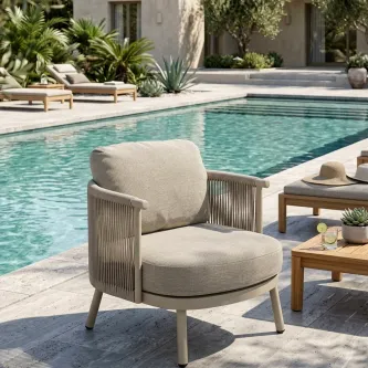 Poltrona de jardim Sabbia junto à piscina com estofos bege e braços em corda.