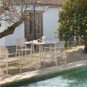 Mesa de jardim sabbia d120 com quatro cadeiras junto a piscina e limoeiro