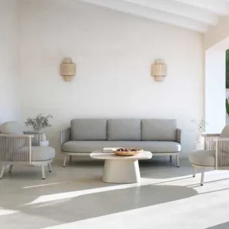 Mesa de centro Jardim Sabbia oval num pátio luminoso com sofá e poltronas