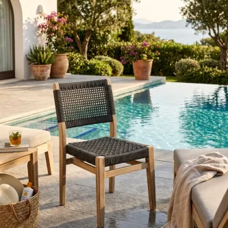 Cadeira de jardim Plaza em madeira clara com assento e encosto trançados junto a piscina
