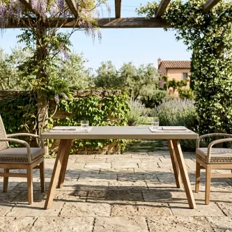 Mesa de jardim Atesso retangular em madeira com duas cadeiras num pátio ajardinado