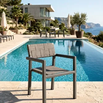 Cadeira de jardim com braços Cube cinzenta junto à piscina com vista mar