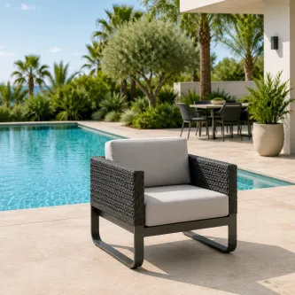 Poltrona de jardim Star em vime sintético escuro com almofadões cinzentos junto à piscina
